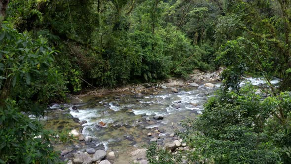 Zooming out from a tropical river covered in boulders