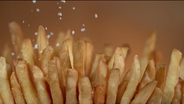 Super Slow Motion Detail Shot of Adding Salt on Fresh French Fries at 1000Fps