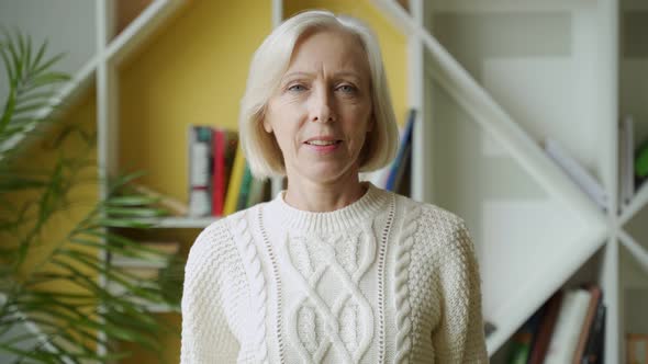 Smiling Middle Aged Mature Grey Haired Woman Looking at Camera, Happy Old Lady Posing at Home Indoor