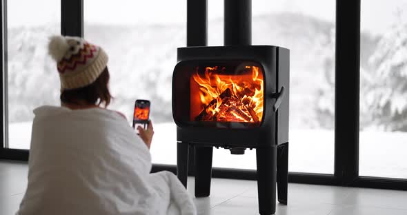 Woman at Home with Burning Fireplace During Wintertime on Nature