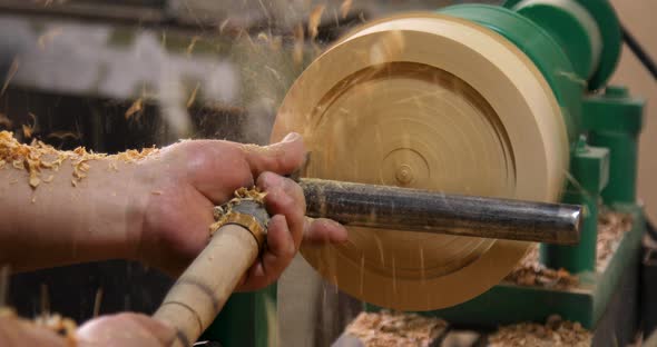 Closeup of carpenter turning wood on a lathe