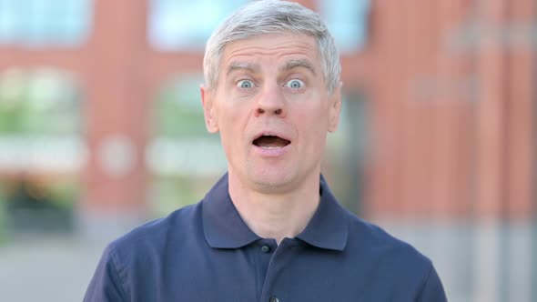 Outdoor Portrait of Middle Aged Man Shaking Head As Yes Sign