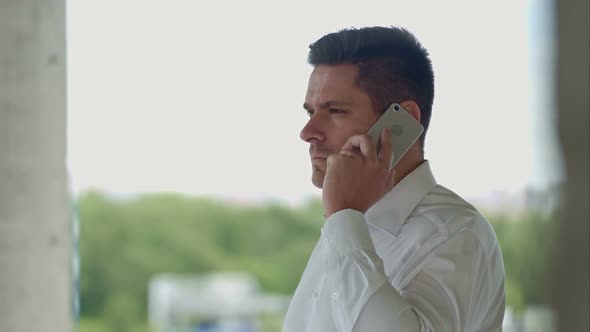 Architect Talking By Phone Standing at Construction Site