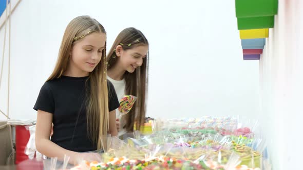 Cute Teenage Girls Look Forward to Brightly Colored Candies and Lollipops