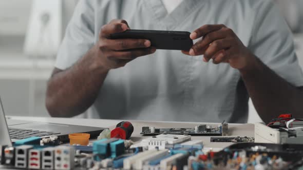 Engineer Photographing Electronics with Smartphone