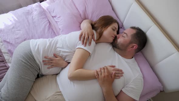 Pregnant Woman and a Man in White T-shirts Lying