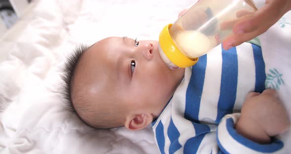 Asian Baby Drinking Milk From A Bottle