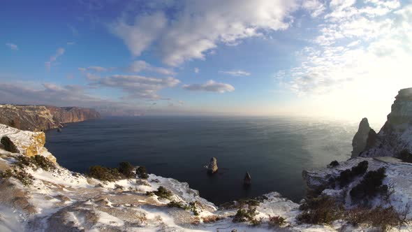 Snow Covered Rocky Cliffs Over Sea