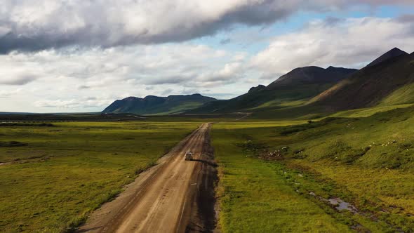 Car trip through the mountain vale in Alaska, USA - aerial flyover