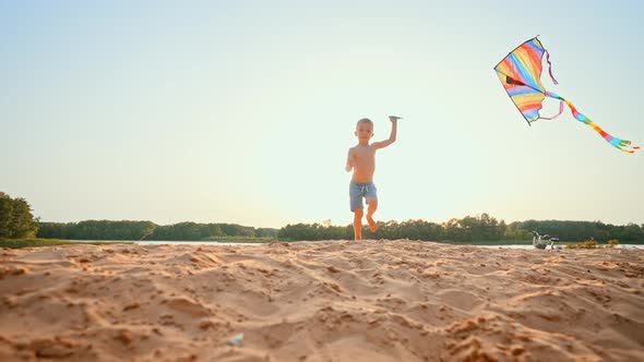 Happy Boy is Flying a Kite on the Beach