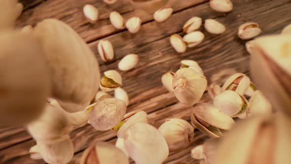 Super Slow Motion Shot of Fresh Roasted Pistachio Nuts Falling on Wooden Table at 1000 Fps