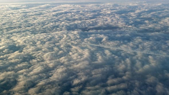 Incredible view from the cockpit of an airplane flying high above the clouds leaving a long white co