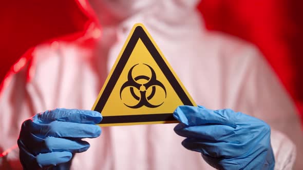 The Doctor Holds a Biohazard Sign in the Coronavirus Infection Area