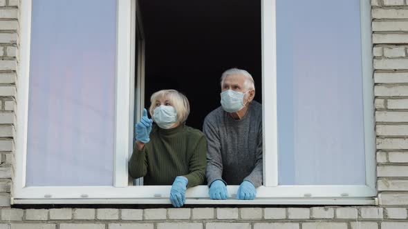 Old Grandparents Stay at Window Isolated at Home on Quarantine. Coronavirus