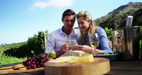 Happy couple discussing over mobile phone while having wine 4k