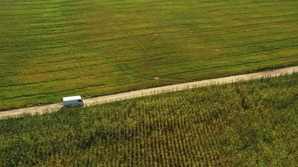 Elevated Top View Of Van Car Vehicle Automobile Drive Motion On Countryside Road Through Summer