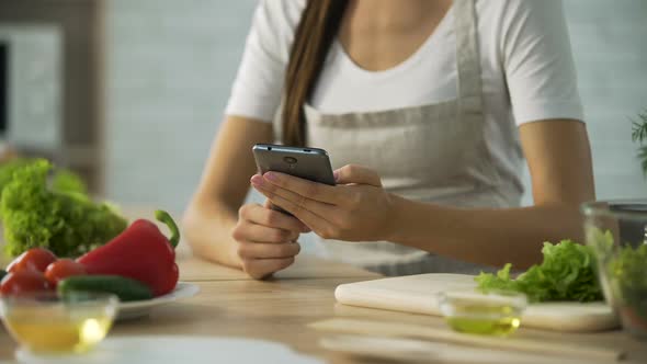 Woman Choosing Salad Recipe on Smartphone at the Kitchen, Cooking Application