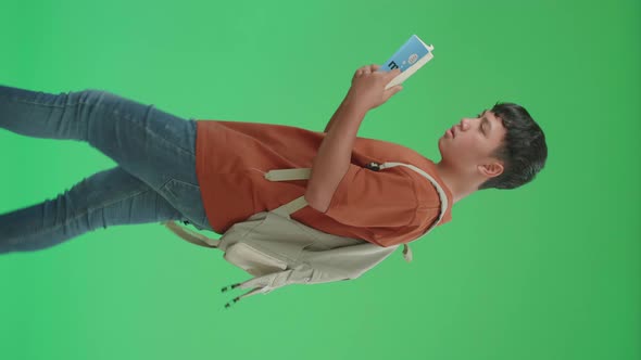 Asian Boy Student Wearing A Backpack, Reading A Book While Walking To School On Green Screen