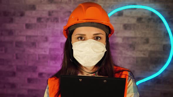 Portrait of Female Construction Worker in Overalls and Medical Mask, Being Isolated at Home Against