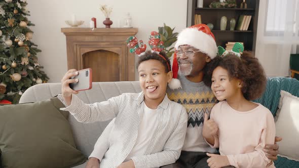 Happy African American Grandfather and Grandchildren Posing to Smartphone Grimacing and Smiling