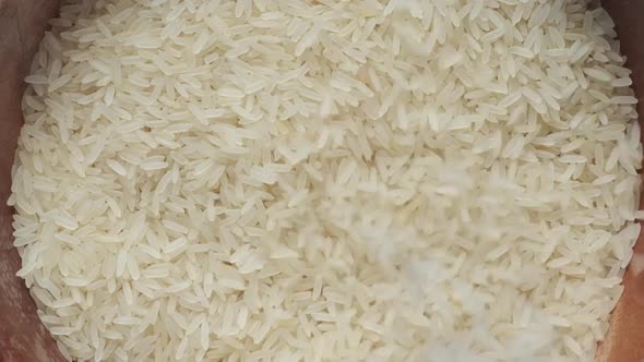 Falling Long Grain Brown Rice in a Bowl on White Background