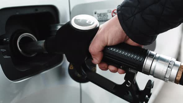 Hand Puts Diesel Fuel Pump Into Car