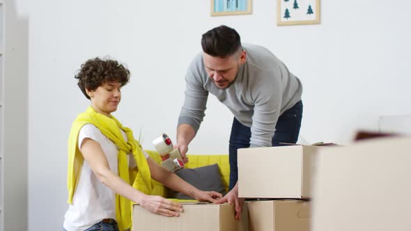 Caucasian Couple Packing Cardboard Boxes for Storage