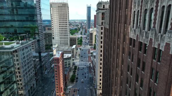 Rising aerial of downtown urban city skyscrapers in American city. Shadows on street and traffic bel