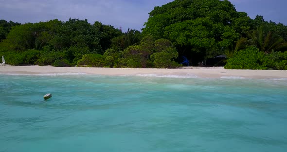 Wide angle drone clean view of a white paradise beach and turquoise sea background in vibrant 4K