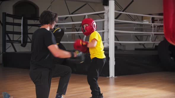 Little Smiling Boy in Protective Helmet Doing Boxing with a Coach