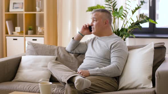 Happy Man Calling on Smartphone at Home