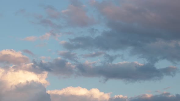 Gray-blue and pink clouds float through the sky at sunset