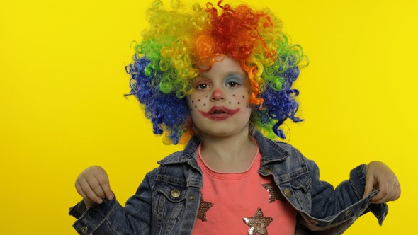 Little Child Girl Clown in Colorful Wig Making Silly Faces. Having Fun, Smiling, Dancing. Halloween