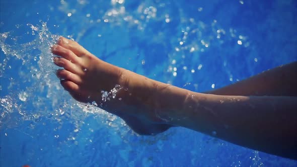 Close Up Shot of the Feet of a Girl Who Wounds Them in the Pool Water