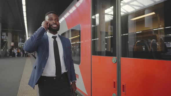 Attractive Businessman Talking By Mobile Phone While Waiting for Train in Metro