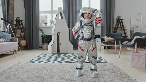Cute Boy in Spacesuit Saluting before Camera