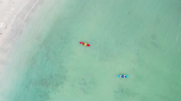 4K Aerial view of Young Asian man and woman friends kayaking together in the sea on summer vacation.
