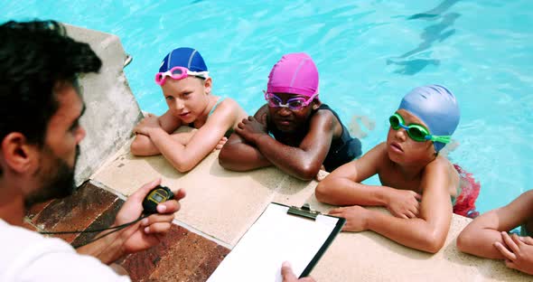 Coach giving swimming lesson to his students