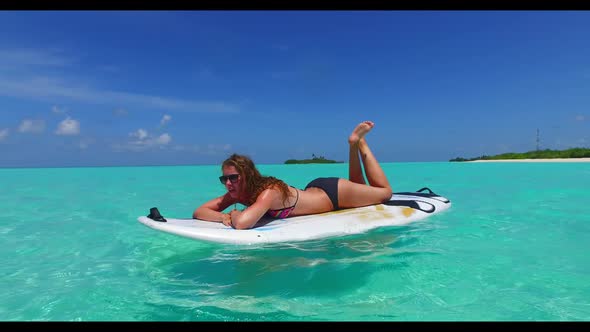 Women posing on tropical coast beach trip by aqua blue lagoon and white sand background of the Maldi