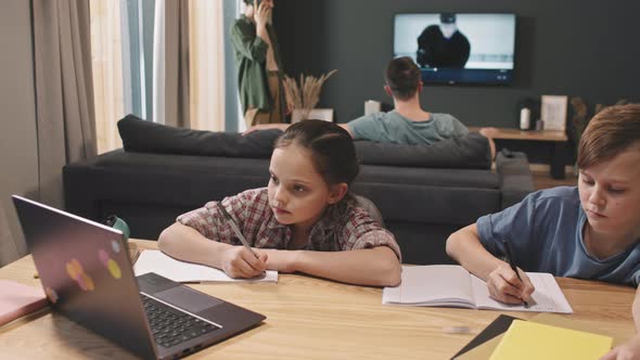 Siblings Studying Online On Laptop