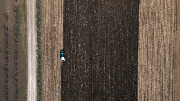 Aerial View of a Tractor Pulling a Plow in a Farmer's Field