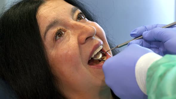 Dentist Holds Dental Instruments in Client's Mouth