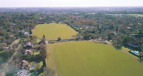 AERIAL - Beautiful green fields at a golf club, wide shot backwards