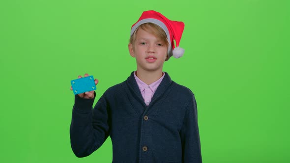 Teenager in the New Year Hat with a Credit Card Shows Like on a Green Screen