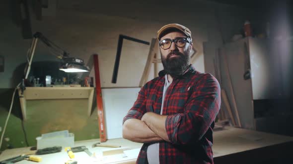 Portrait of a Bearded Man in Glasses Who is Standing with His Arms Crossed