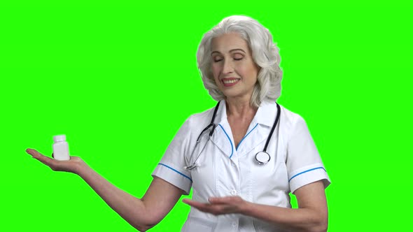 Senior Doctor Presenting Pills on Green Screen