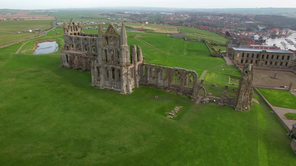 Abbey ruins and Cholmley House or Whitby Hall with Stone Garden, Whitby in England. Aerial circling