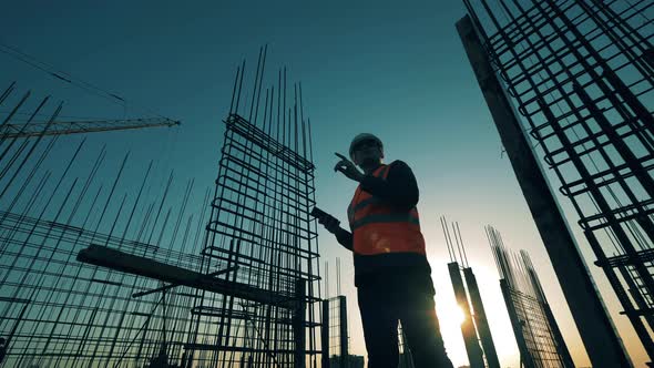 Constructor Is Making Calculations at the Rooftop Building Lot