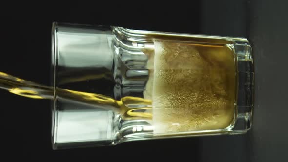 Vertical Video Cola is Poured Into Faceted Glass Full of Bubbles and Foam Isolated on Black
