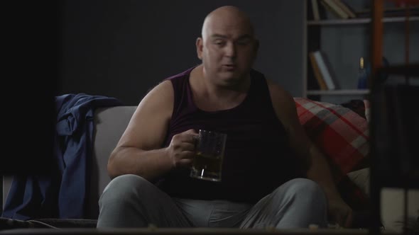 Plump Guy Watching TV With Popcorn and Beer, Unemployment and Laziness Problems